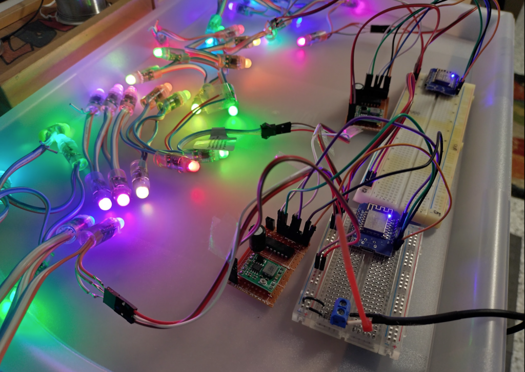 Four 10 LED strands of 12v WS2811 pixels, controlled by two nodeMCU mini boards running wled, powered (and switched) by two custom 12v-5v regulator SN74HC125N veroboards - ready for xlights.